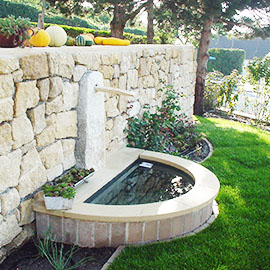 Brunnen an einer Steinmauer